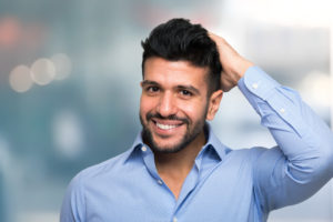 Portrait of a man touching his hair after a succesful hair transplant