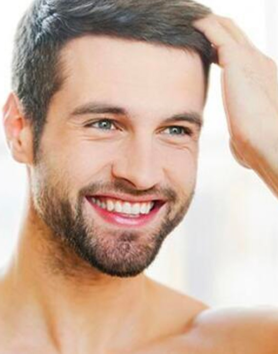 A man smiling after a succesful hair transplant